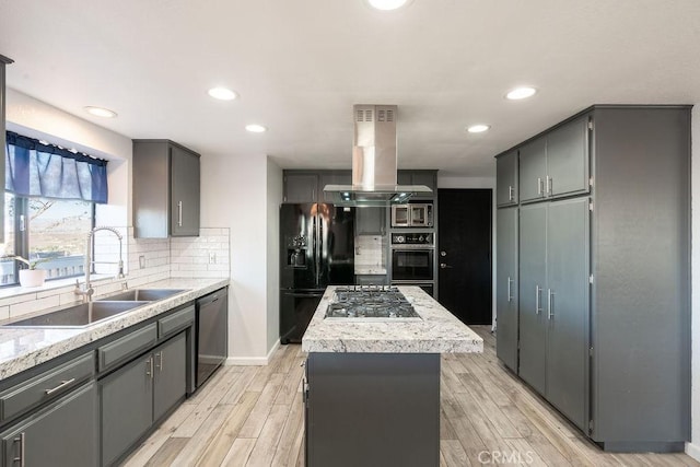 kitchen with a center island, light countertops, a sink, island range hood, and black appliances