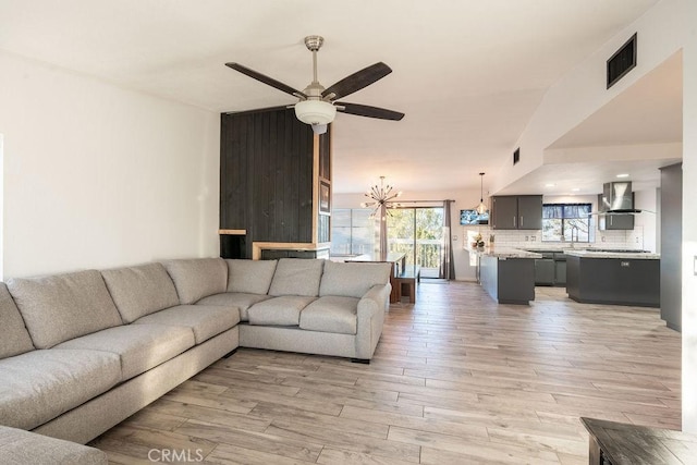 living room with light wood finished floors, visible vents, and a ceiling fan