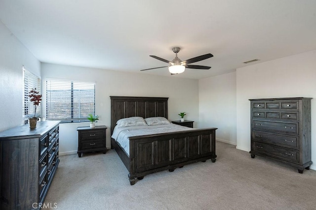 bedroom featuring ceiling fan, visible vents, baseboards, and light colored carpet