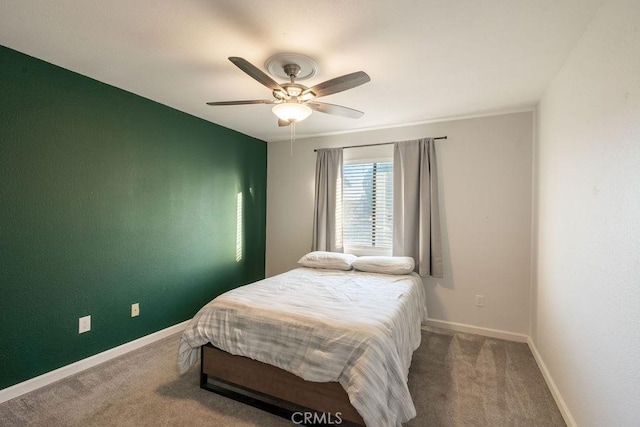 carpeted bedroom featuring baseboards and a ceiling fan