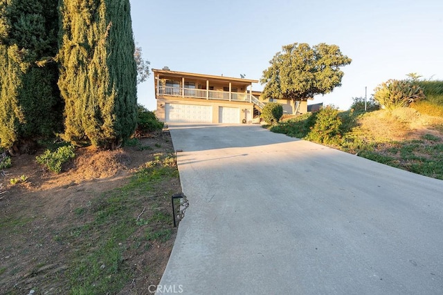 view of front of property with a garage, driveway, covered porch, and a balcony