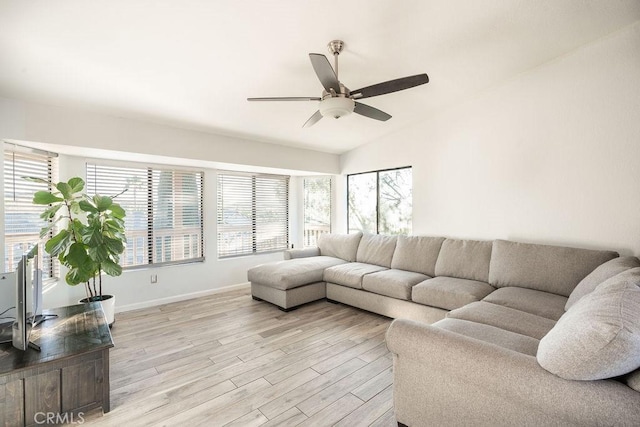 living room with light wood-style floors, lofted ceiling, ceiling fan, and baseboards