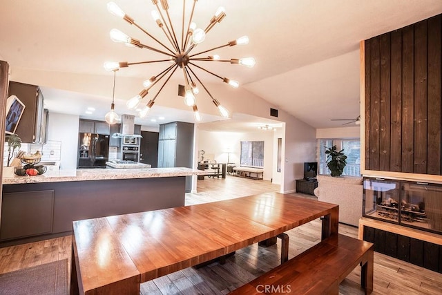 dining space with lofted ceiling, light wood-style floors, ceiling fan, and visible vents