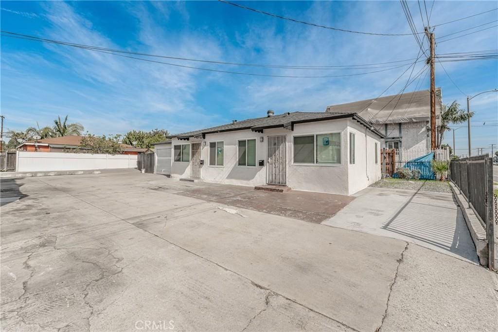 ranch-style house featuring fence private yard and stucco siding