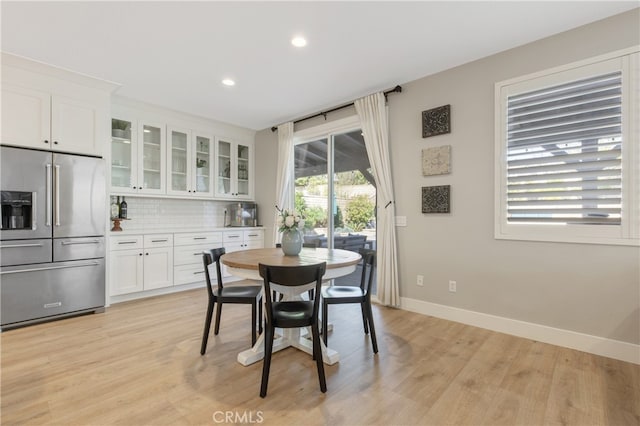 dining space with recessed lighting, light wood-style flooring, and baseboards