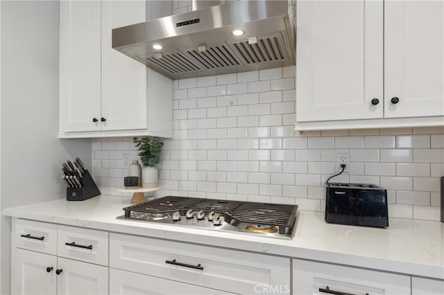 kitchen featuring white cabinetry, ventilation hood, and light stone countertops