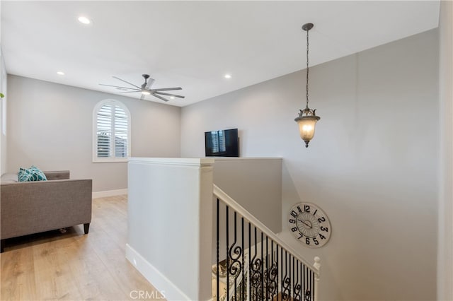 hall with recessed lighting, baseboards, an upstairs landing, and wood finished floors