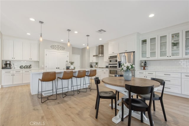 dining space featuring light wood-type flooring, visible vents, and recessed lighting