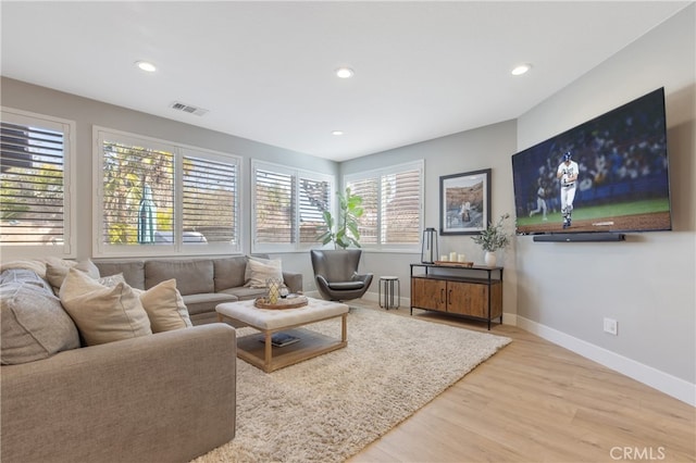 living room featuring baseboards, visible vents, wood finished floors, and recessed lighting