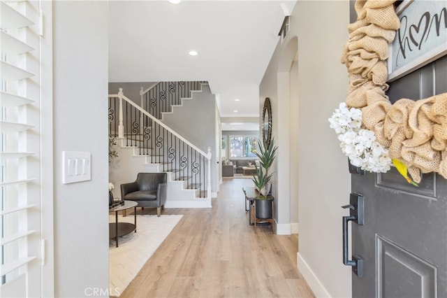 foyer entrance featuring baseboards, stairway, wood finished floors, and recessed lighting