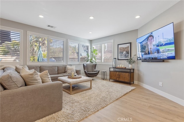 living area with baseboards, visible vents, wood finished floors, and recessed lighting