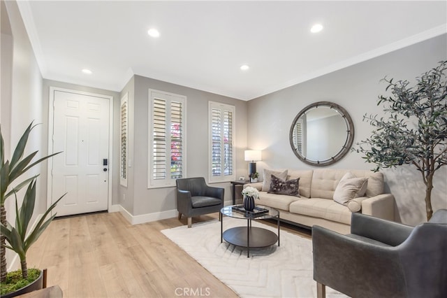 living area with ornamental molding, recessed lighting, light wood-style flooring, and baseboards