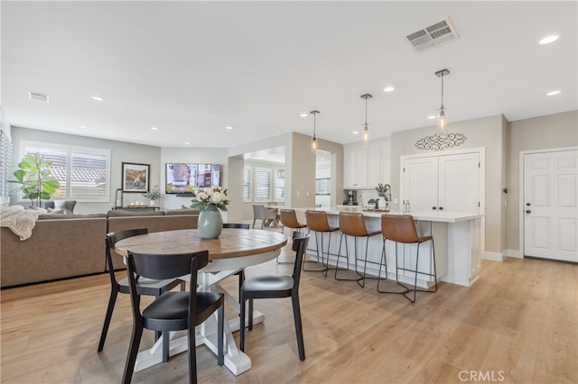 dining area featuring baseboards, light wood-type flooring, visible vents, and recessed lighting