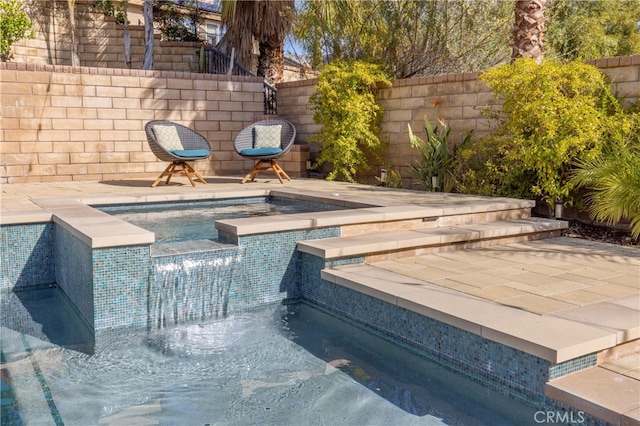 view of pool with a pool with connected hot tub and a fenced backyard