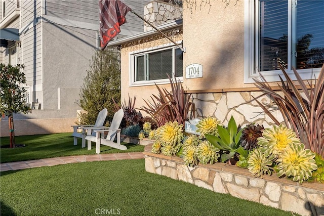 view of side of home featuring stucco siding and a lawn