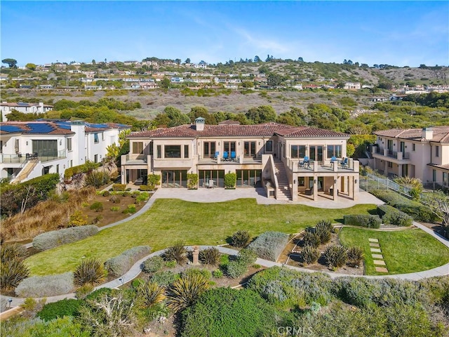 back of property featuring a patio, a lawn, a balcony, and stucco siding