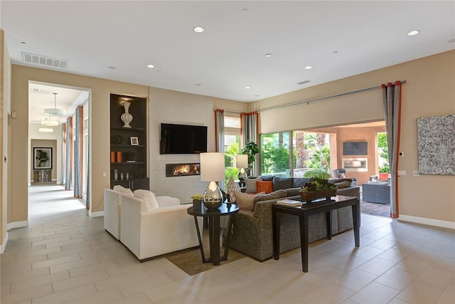 living area with built in features, recessed lighting, visible vents, a large fireplace, and baseboards