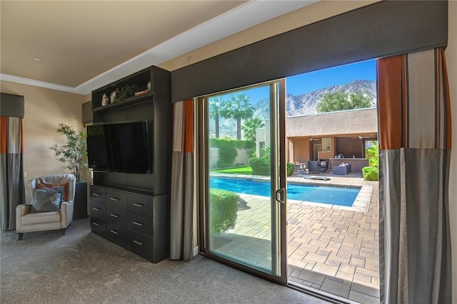 doorway featuring dark colored carpet and crown molding
