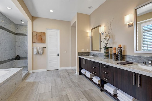 full bath featuring double vanity, a sink, and a walk in shower