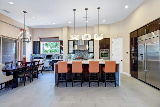 kitchen featuring dark brown cabinets, a kitchen island, stainless steel appliances, and light countertops