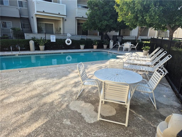 community pool featuring fence and a patio