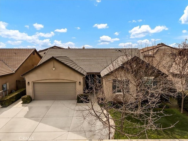 view of front facade with a garage, a tile roof, concrete driveway, and stucco siding