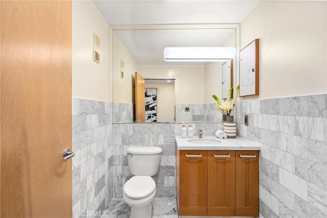 bathroom featuring tile walls, visible vents, vanity, and toilet