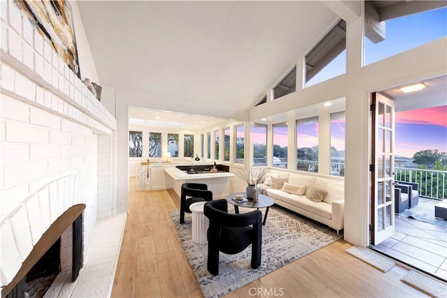 11 Montpellier, Newport Beach, CA 92660 - living area with light wood-style floors, a brick fireplace, beam ceiling, and high vaulted ceiling