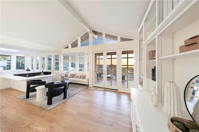 sunroom / solarium featuring vaulted ceiling with beams and french doors