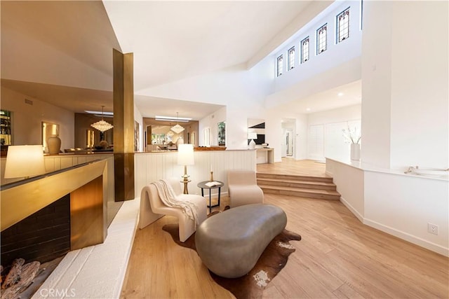11 Montpellier, Newport Beach, CA 92660 - living area featuring light wood finished floors, a high ceiling, a chandelier, baseboards, and a fireplace