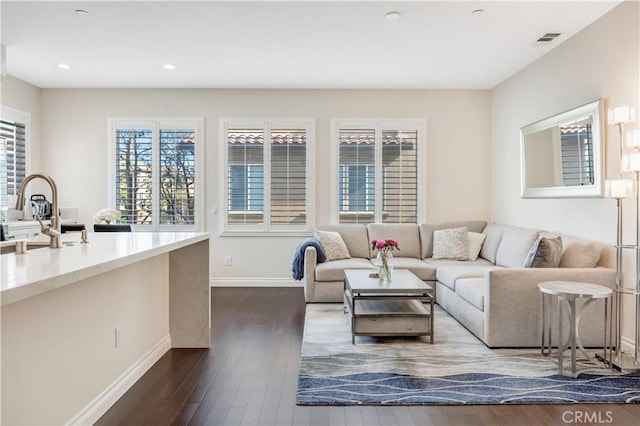 living room featuring dark wood-style flooring, recessed lighting, visible vents, and baseboards