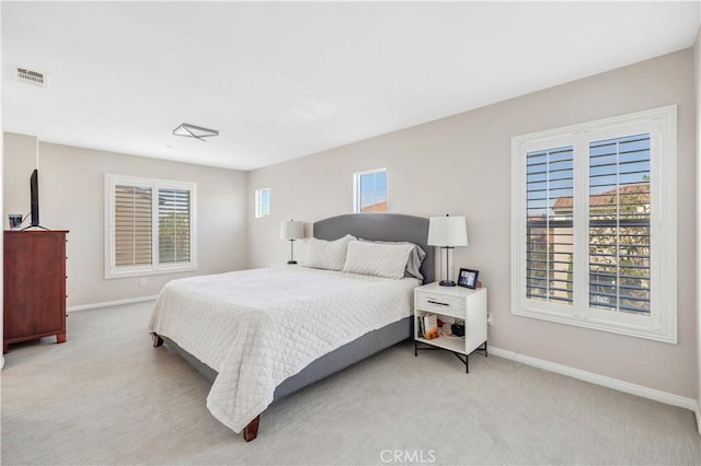 bedroom with light carpet, multiple windows, and visible vents