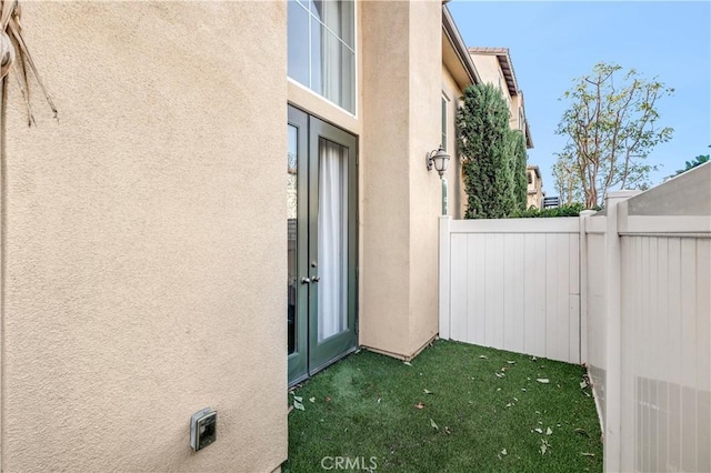 property entrance featuring fence and stucco siding