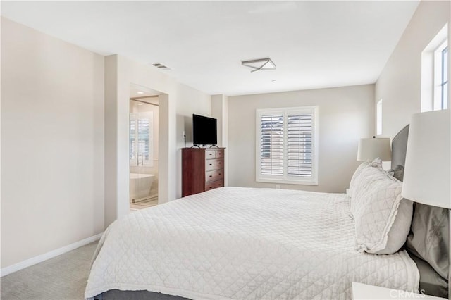 bedroom with light colored carpet, visible vents, connected bathroom, and baseboards