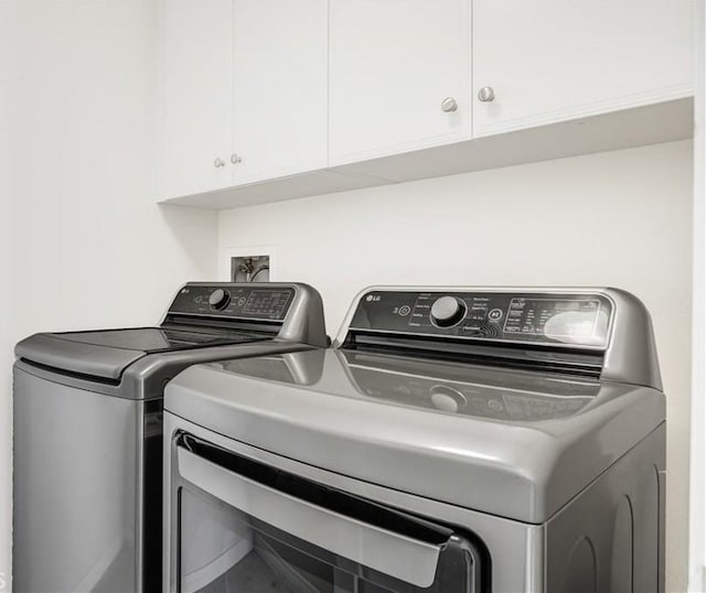 washroom with washing machine and dryer and cabinet space