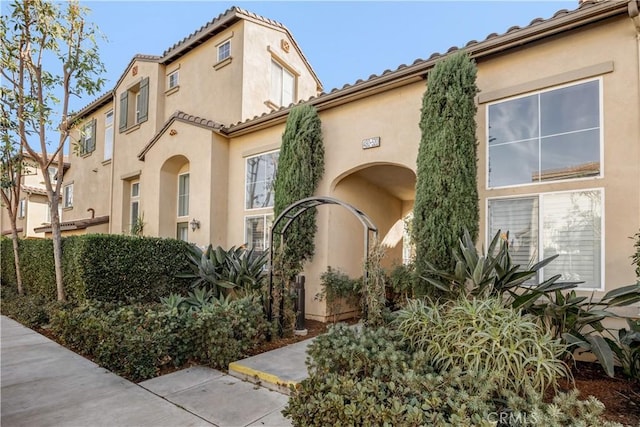 view of front of property featuring a tiled roof and stucco siding