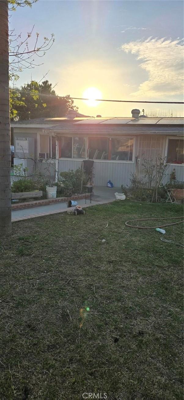 view of front of house with a patio and a yard