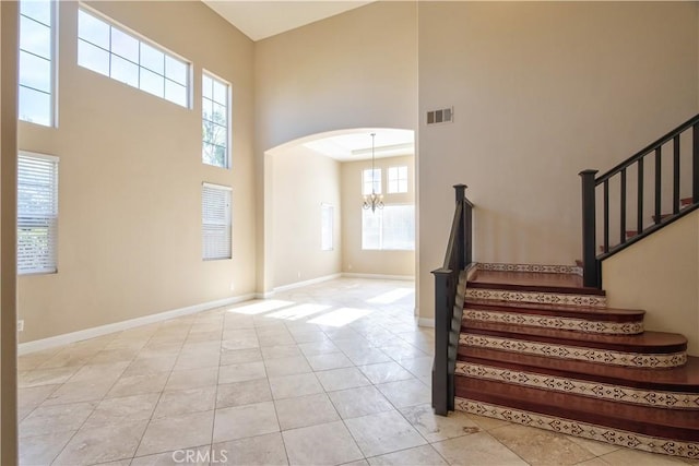 23531 Hobart Ct, Murrieta, CA 92562 - foyer entrance with a towering ceiling, a chandelier, stairs, light tile patterned floors, and arched walkways