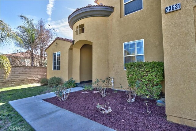 23531 Hobart Ct, Murrieta, CA 92562 - view of exterior entry featuring stucco siding, a tiled roof, and a patio