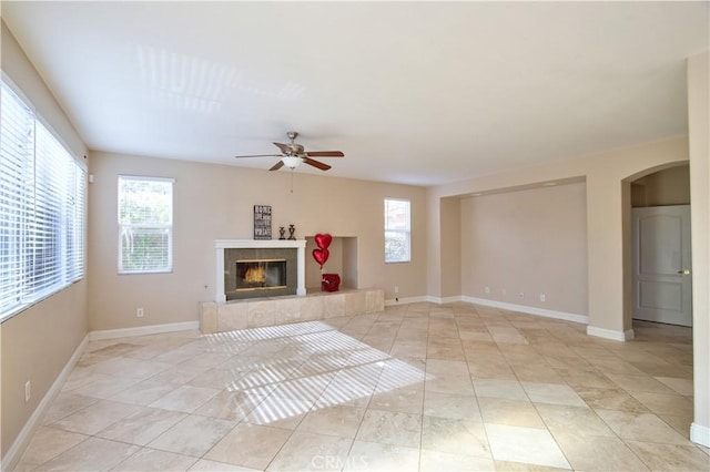 23531 Hobart Ct, Murrieta, CA 92562 - unfurnished living room featuring healthy amount of natural light, ceiling fan, a tile fireplace, and arched walkways