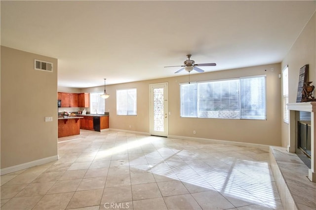 23531 Hobart Ct, Murrieta, CA 92562 - unfurnished living room featuring ceiling fan, light tile patterned flooring, a glass covered fireplace, and baseboards