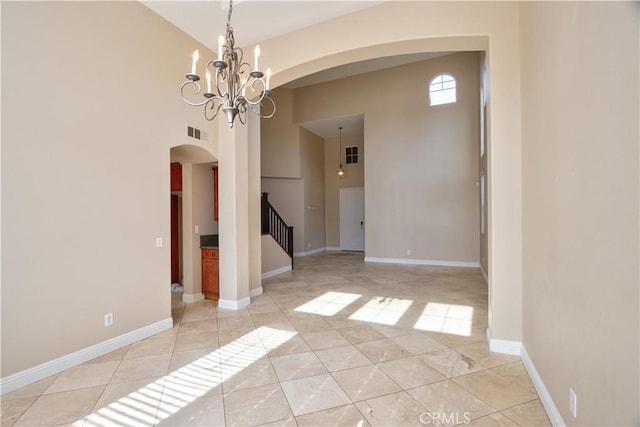 23531 Hobart Ct, Murrieta, CA 92562 - unfurnished room with arched walkways, a high ceiling, stairway, a chandelier, and light tile patterned floors