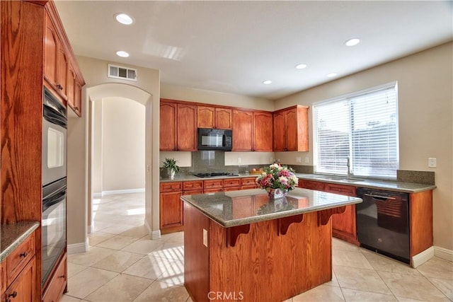 23531 Hobart Ct, Murrieta, CA 92562 - kitchen featuring black appliances, light tile patterned floors, a breakfast bar, arched walkways, and recessed lighting
