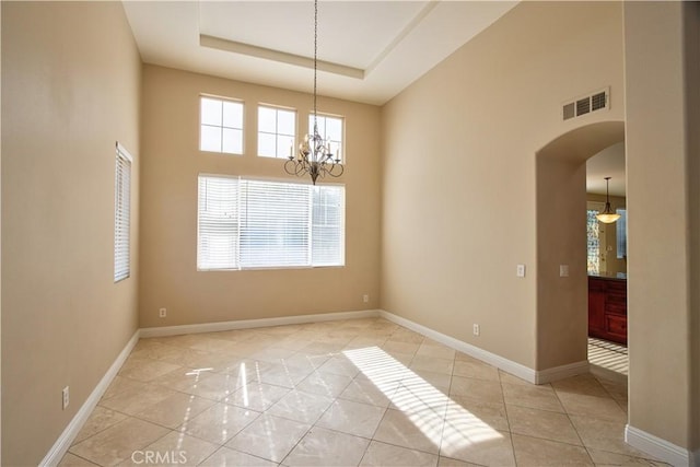 23531 Hobart Ct, Murrieta, CA 92562 - empty room with arched walkways, light tile patterned floors, a chandelier, a towering ceiling, and a raised ceiling