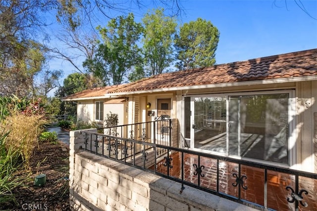 back of property featuring a tiled roof