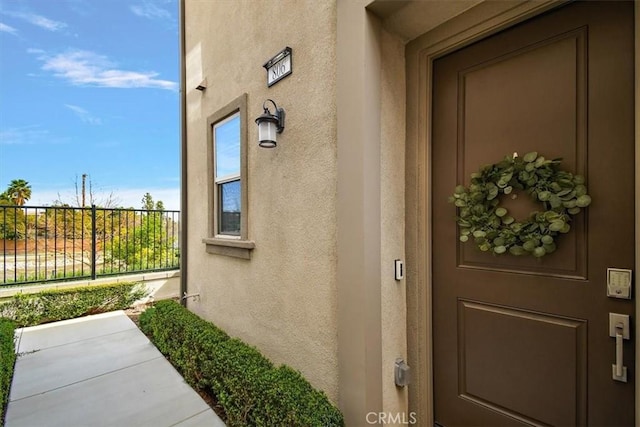 entrance to property featuring stucco siding