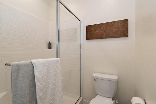 full bath featuring a stall shower and toilet