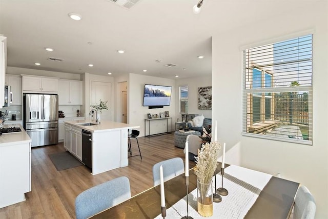 dining space featuring visible vents, light wood-style flooring, and recessed lighting