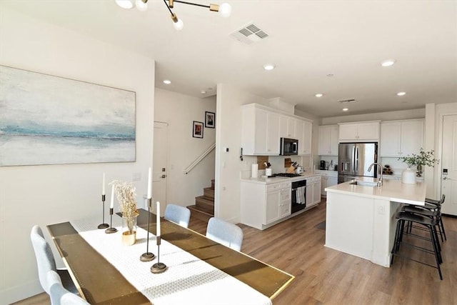 dining space with stairway, recessed lighting, visible vents, and light wood-style flooring