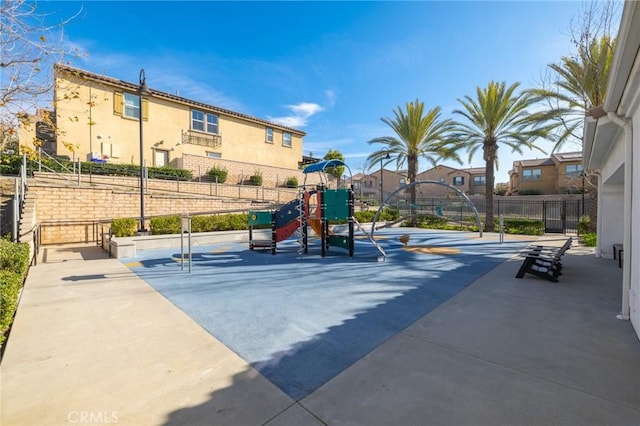 communal playground featuring a residential view and fence